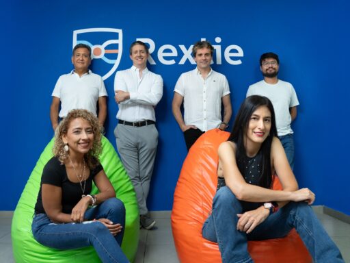 Equipo diverso sonriendo en oficina con logo Rexxie
