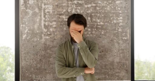 Hombre frustrado cubriéndose la cara con la mano