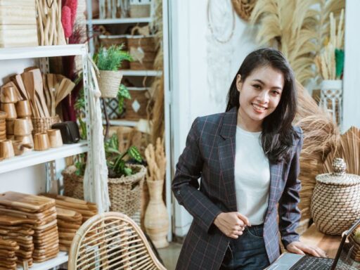 Empresaria en tienda de artesanías con laptop