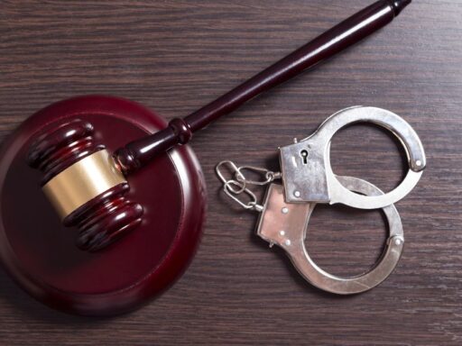 Mazo y esposas sobre mesa de madera