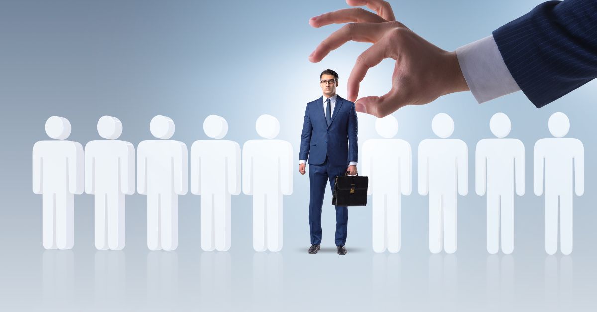 Mano seleccionando ejecutivo entre siluetas blancas