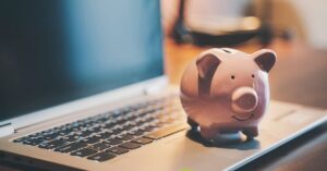 Alcancía cerdo sobre laptop, concepto de ahorro digital