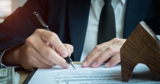 Hombre firmando documentos legales con sello y dinero
