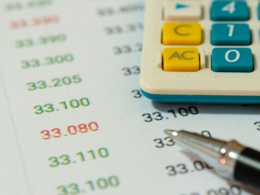 Calculadora y bolígrafo sobre papel con cifras financieras