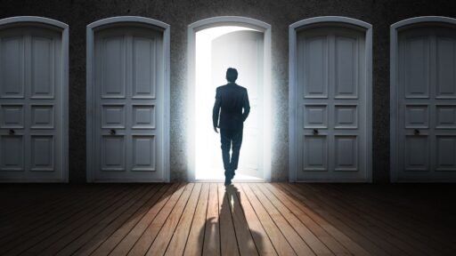 Hombre frente a puerta abierta entre cerradas