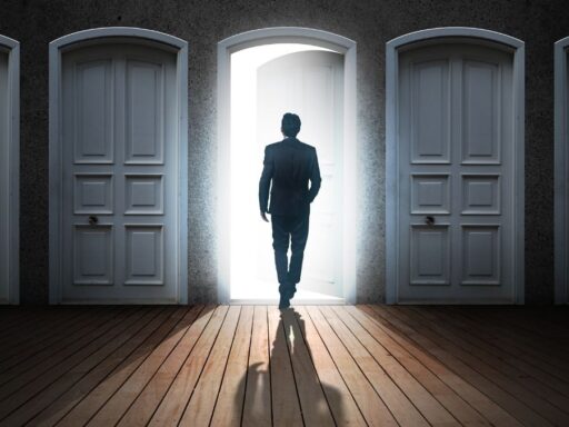 Hombre frente a puerta abierta entre cerradas