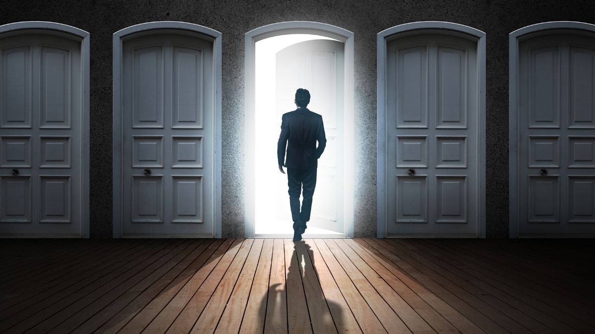 Hombre frente a puerta abierta entre cerradas