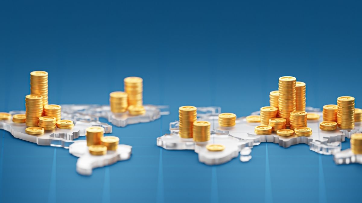 Monedas doradas sobre mapamundi azul, economía global