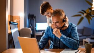 Hombre trabajando desde casa con su hijo pequeño