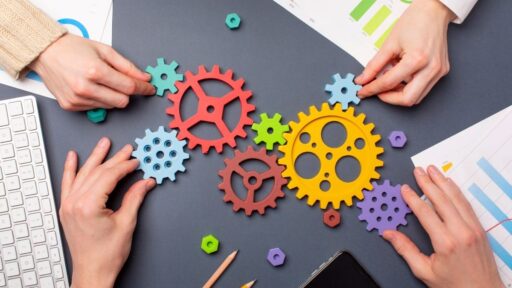 Personas uniendo engranajes de colores sobre mesa