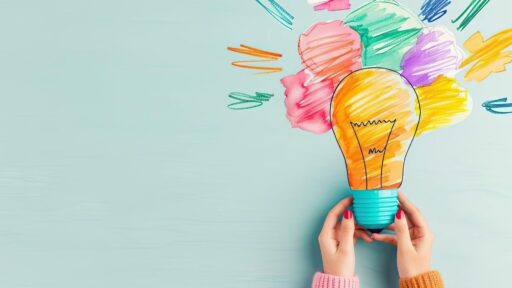 Manos sostienen bombilla con dibujos coloridos