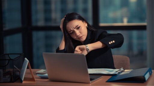 Mujer estresada revisando hora en oficina moderna