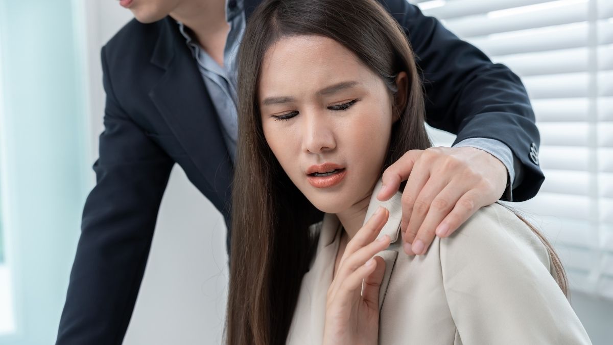 Hombre incomodando a mujer en oficina