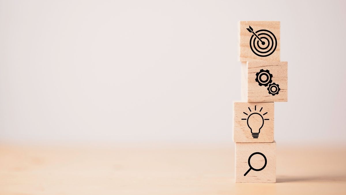 Bloques con íconos de objetivos, engranajes, bombilla y lupa