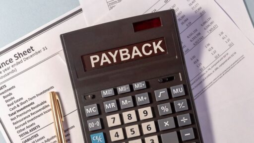 Calculadora con etiqueta 'PAYBACK' sobre hojas financieras