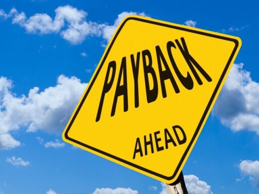 Señal amarilla 'PAYBACK AHEAD' cielo nublado