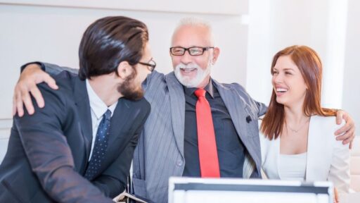 Tres profesionales sonrientes en una reunión de oficina