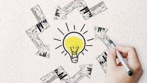 Persona dibujando bombilla con ideas creativas