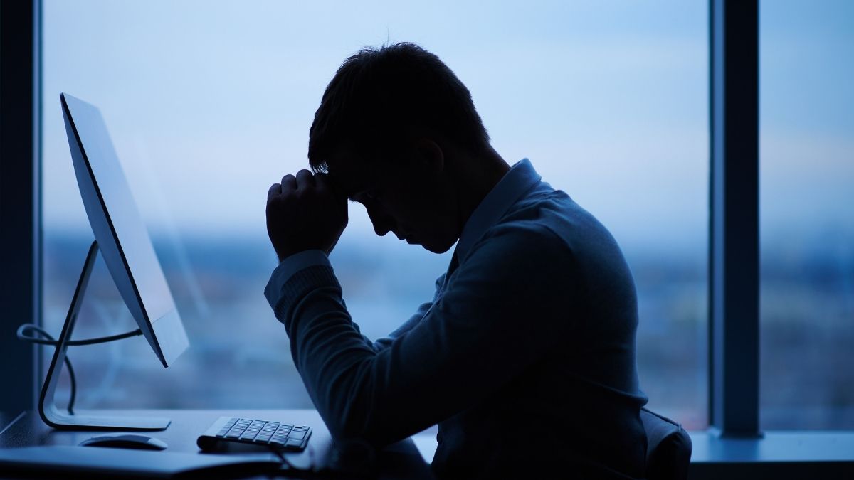 Hombre estresado trabajando tarde en oficina