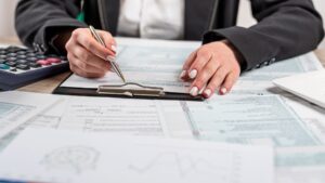 Mujer revisando documentos financieros en oficina