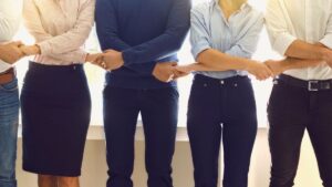Equipo de trabajo unido de manos en oficina
