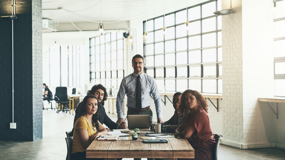 Equipo diverso trabajando juntos en oficina iluminada