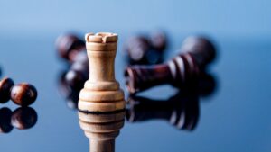 Rey de ajedrez destacándose entre piezas caídas