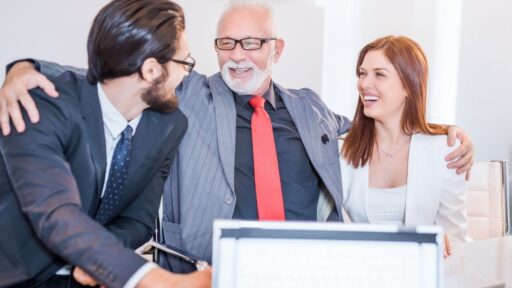 Tres profesionales sonriendo en reunión corporativa