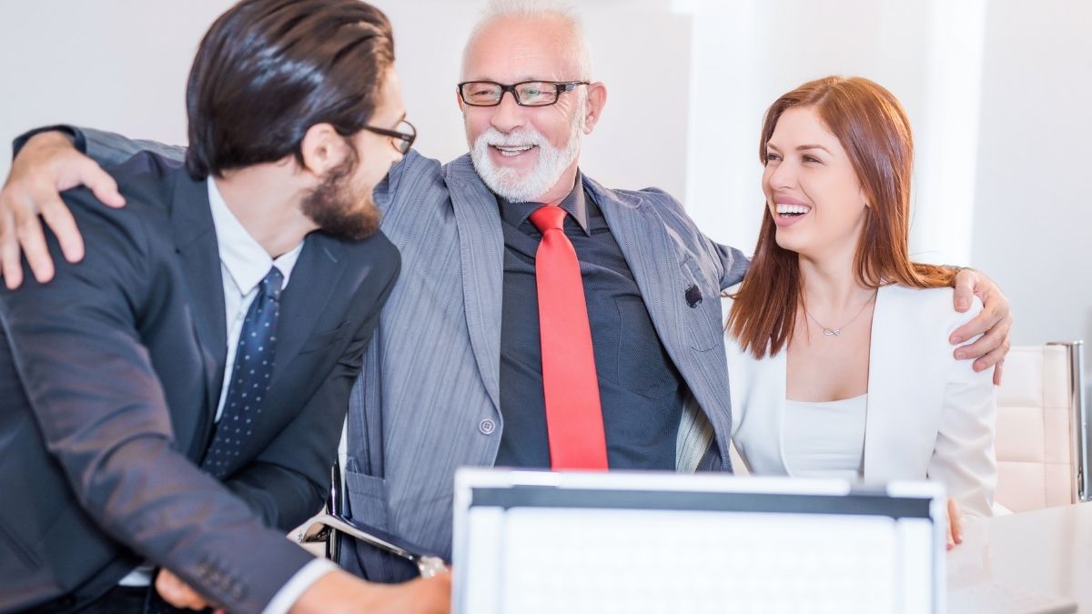 Tres profesionales sonriendo en reunión corporativa