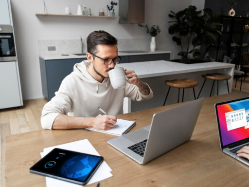 Hombre trabajando en laptop mientras toma café