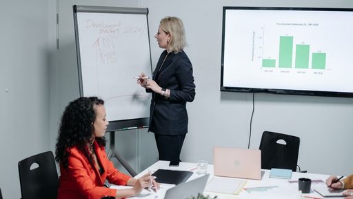 Mujer presenta gráfica durante reunión de estrategia empresarial